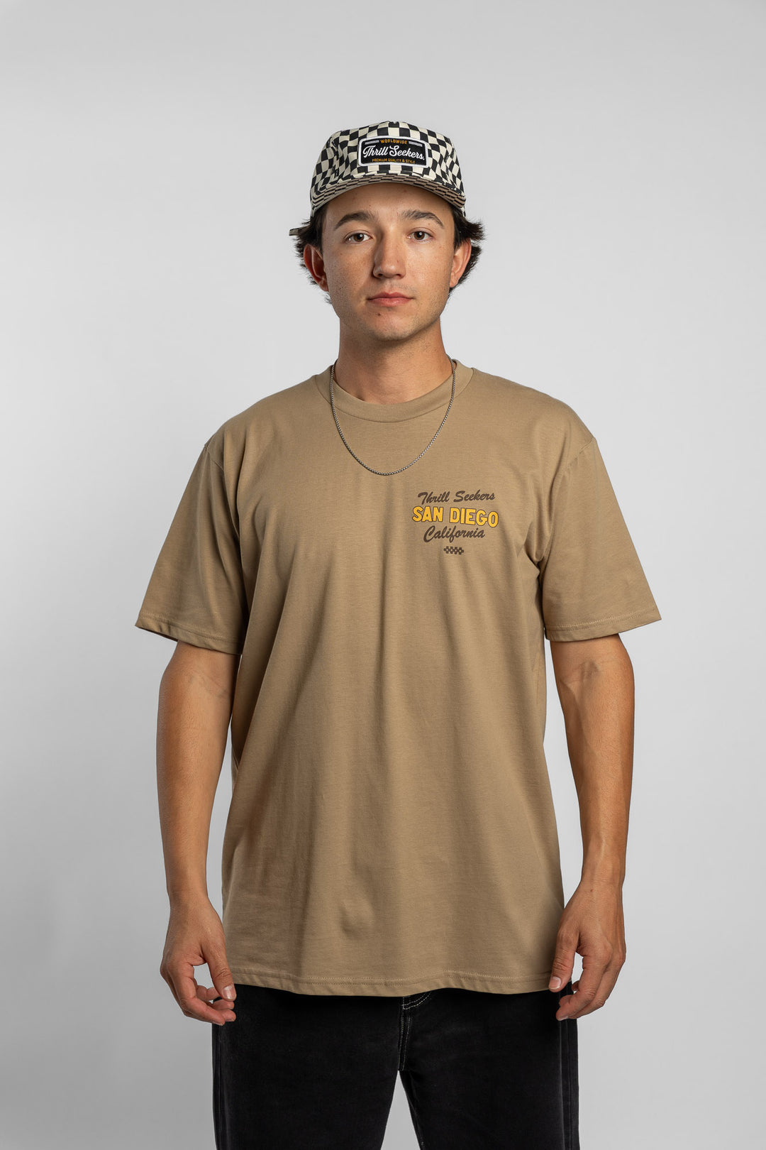 Person wearing sand tee with 'Thrill Seekers' shop logo