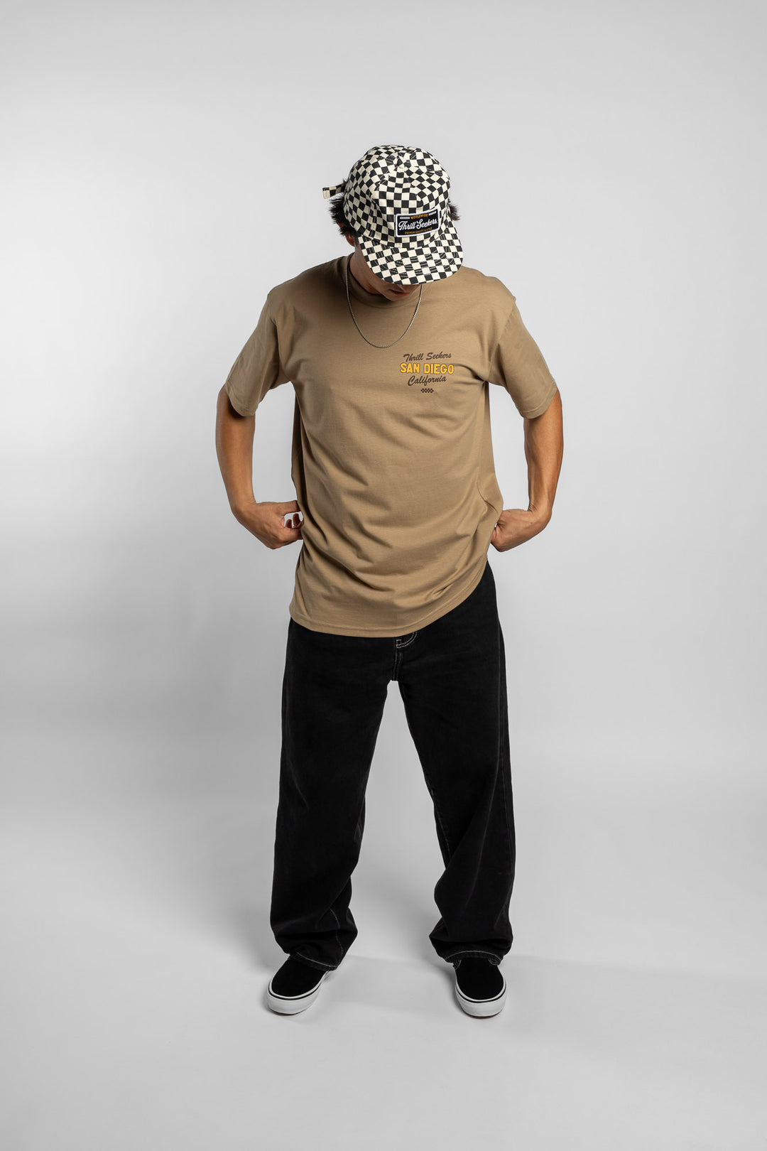 Person wearing sand tee with 'Thrill Seekers' shop logo