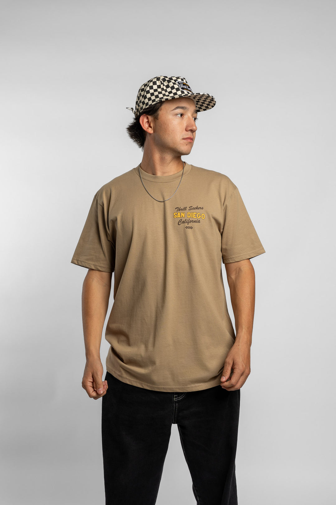 Person wearing sand tee with 'Thrill Seekers' shop logo