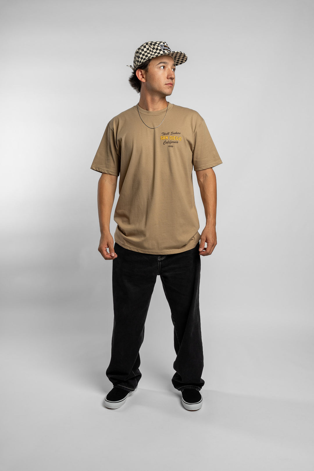 Person wearing sand tee with 'Thrill Seekers' shop logo