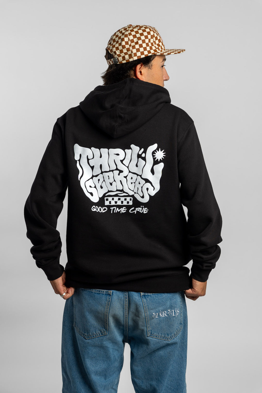 Person wearing a black hoodie with a 'Thrill Seekers' smokin' logo in white