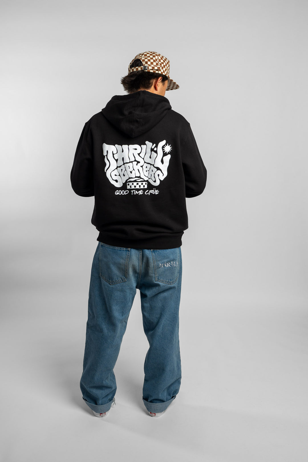 Person wearing a black hoodie with a 'Thrill Seekers' smokin' logo in white