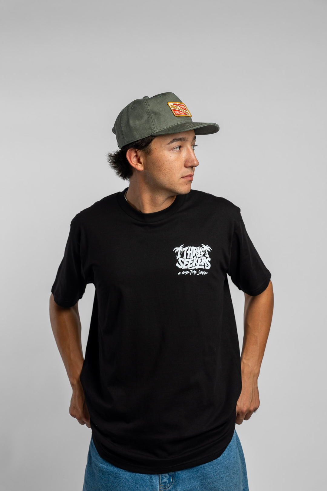 Person wearing black tee with 'Thrill Seekers' good time supply logo in white