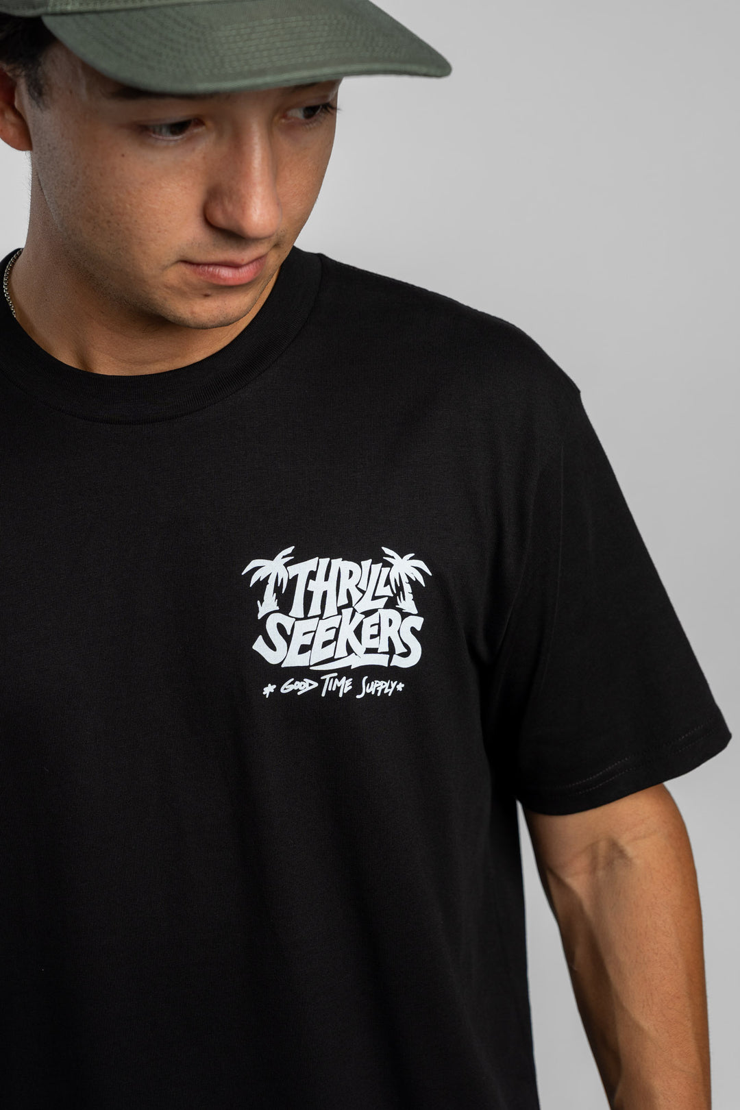 Person wearing black tee with 'Thrill Seekers' good time supply logo in white