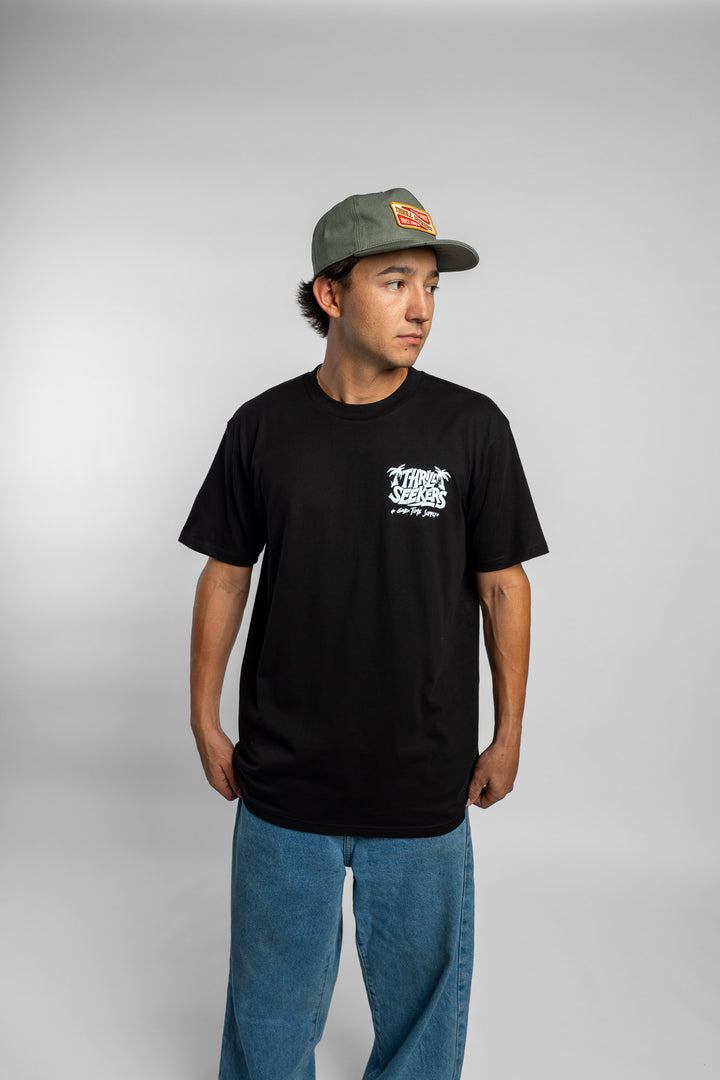 Person wearing black tee with 'Thrill Seekers' good time supply logo in white
