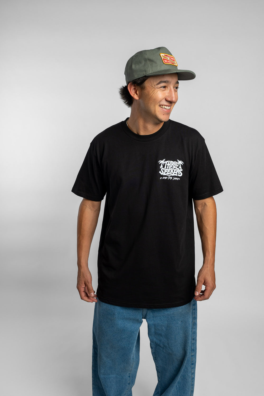 Person wearing black tee with 'Thrill Seekers' good time supply logo in white