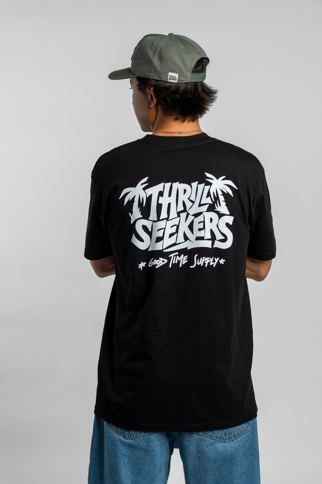 Person wearing black tee with 'Thrill Seekers' good time supply logo in white