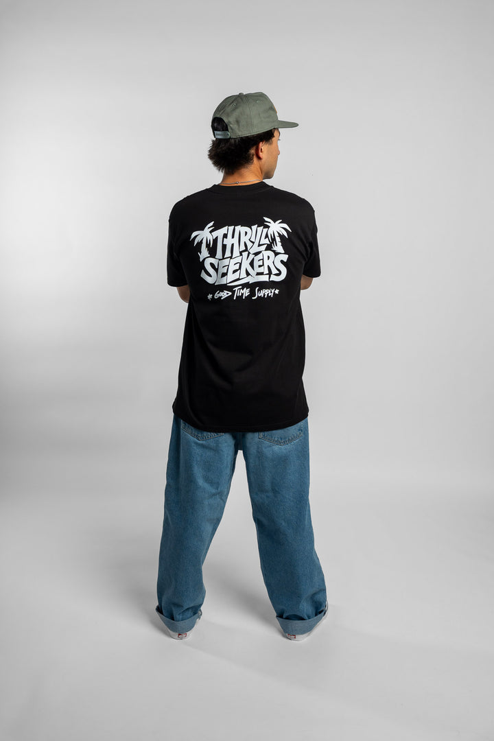 Person wearing black tee with 'Thrill Seekers' good time supply logo in white