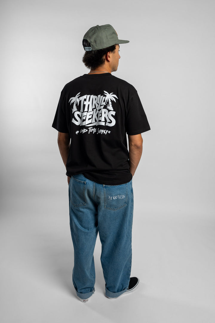 Person wearing black tee with 'Thrill Seekers' good time supply logo in white