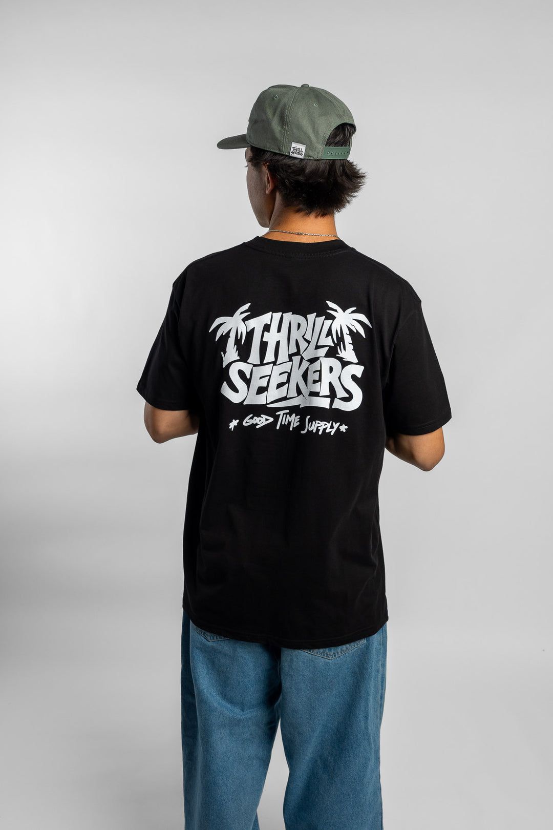 Person wearing black tee with 'Thrill Seekers' good time supply logo in white