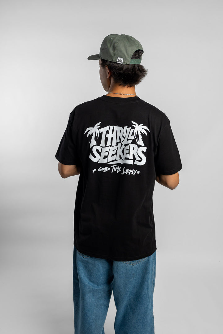 Person wearing black tee with 'Thrill Seekers' good time supply logo in white