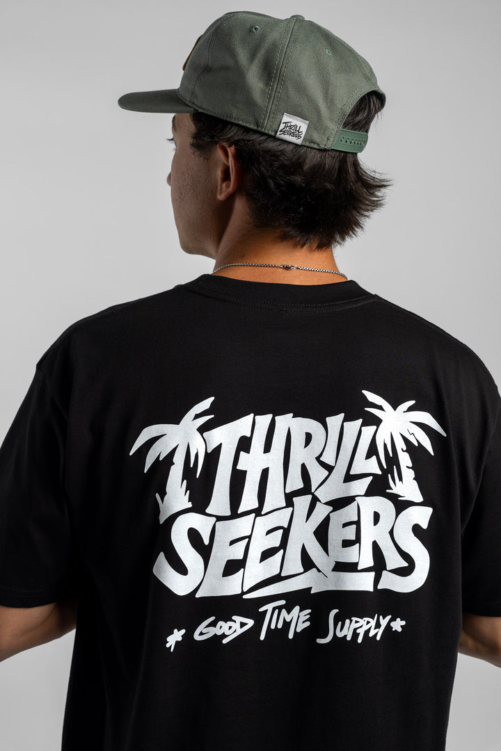 Person wearing black tee with 'Thrill Seekers' good time supply logo in white