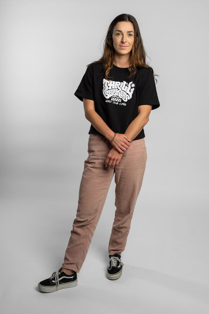 Woman wearing a black crop with 'Thrill Seekers' logo on a white background